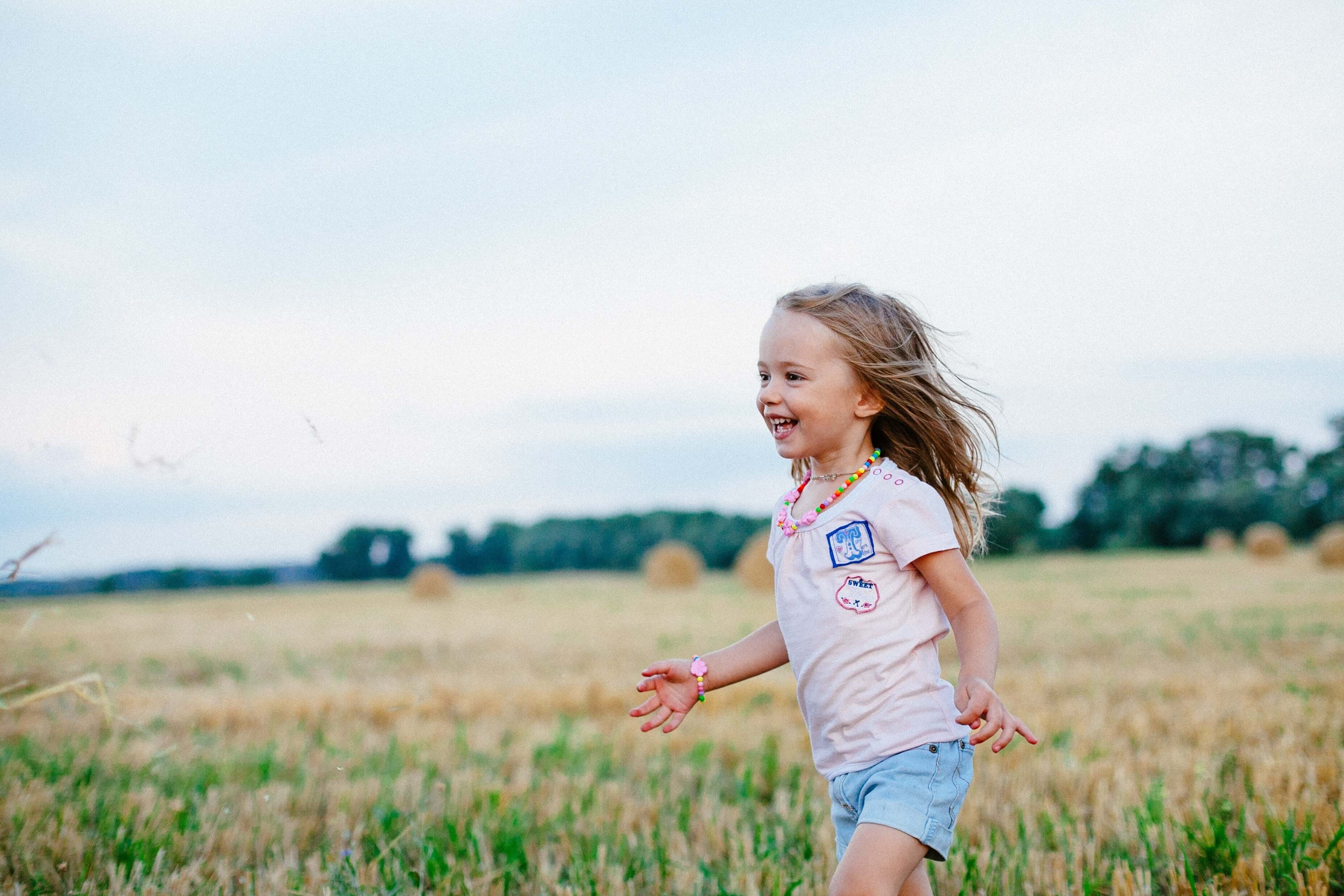 Small, happy girl running in a field